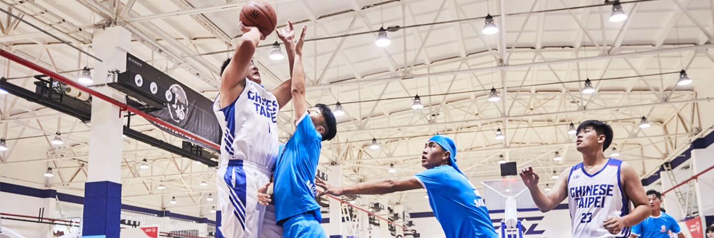Five young men on the court playing basketball
