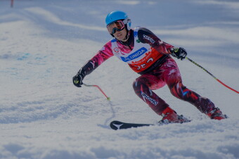 Female athlete skiing down hill. 