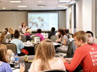 Students sitting at tables looking at a presentation
