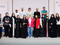 A group of 18 people standing in two rows for a group photo. 