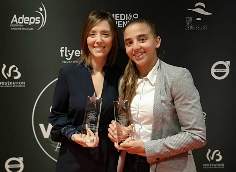 Two young women holding awards.