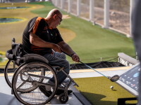 Man in wheelchair playing topgolf. 