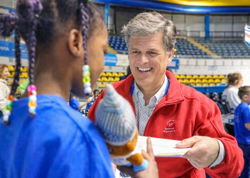 Tim Shriver talking to a young girl. 