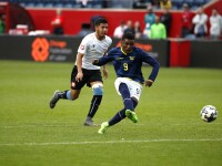 Two football players from opposing teams on the field going after the ball. 