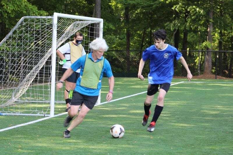A Special Olympics coach instructs his soccer team. 