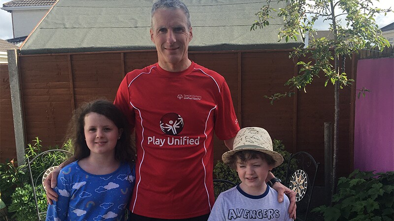 Will Byrne with his two daughters in the back yard after a run. 