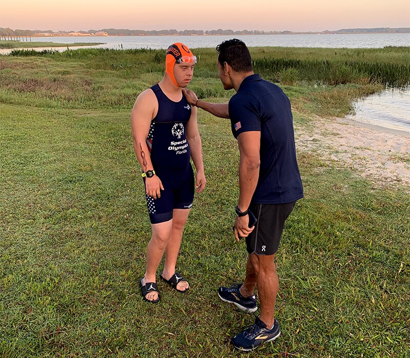 Chris Nikic with a coach on the banks of the water before his swim.