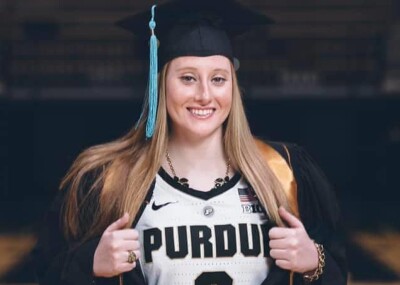 Abby in a graduation cap and gown with a Purdue jersey under.