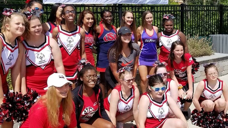 Group of cheerleaders outside posing for a group photo.