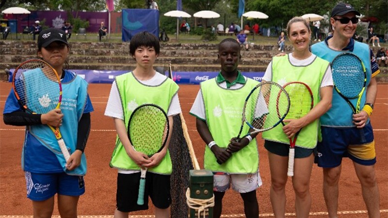 Athletes stand together on court with rackets in hand