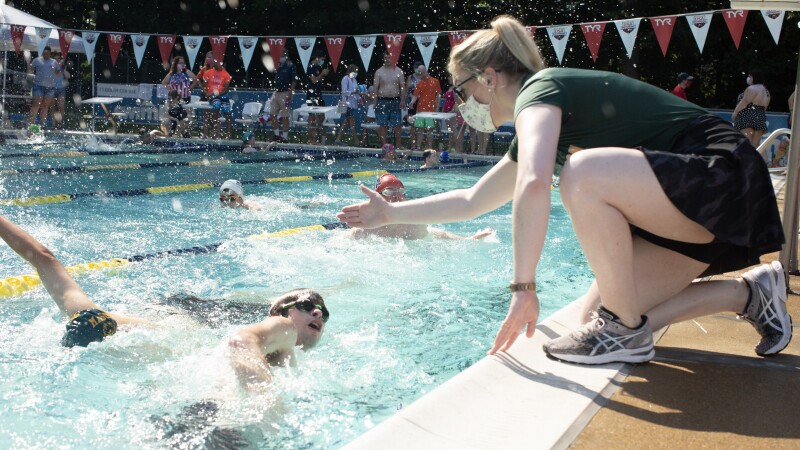 volunteer offering encouragement to an athlete during a swim meet