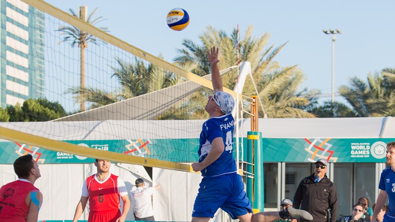 Beach Volleyball player jumping to spike the ball.