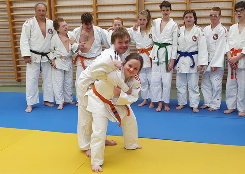 Two athletes demonstrating a move while the class observes.