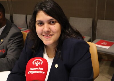 Emanuelle de Souza sitting in front of a microphone.