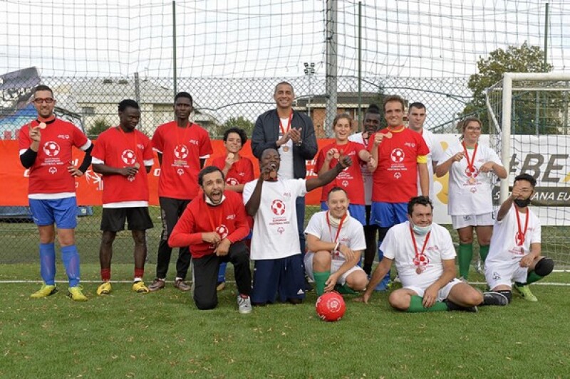 Italian football star David Trezeguet and Unified partner Gerald Mballe celebrating with the other athletes and refugees at the end of the match.