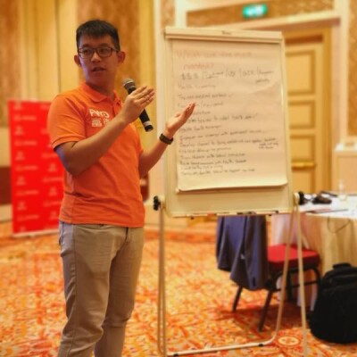 Kurtis standing at a white board in a conference room giving a presentation.