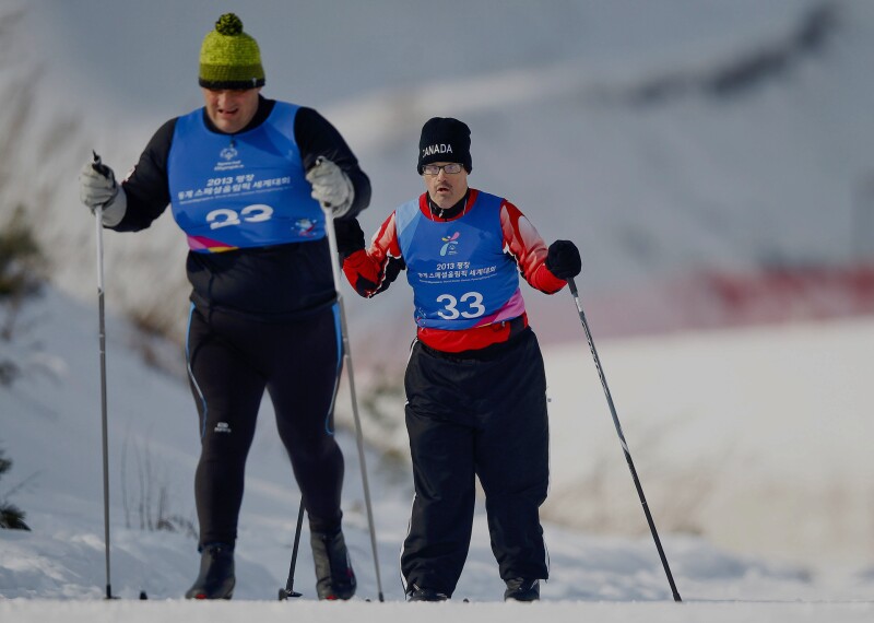 Two male athlete cross country skiers skiing.