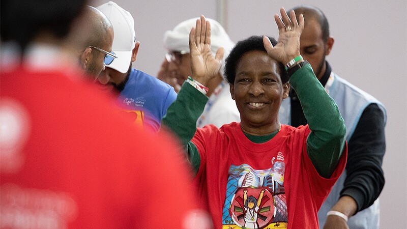 Loretta Claiborne, Special Olympics Board Vice Chair and Chief Inspiration Officer smiling with hands in the air.