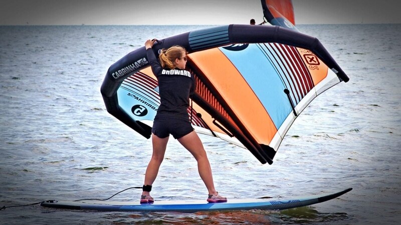 Special Olympics athlete rides paddleboard in the water. 