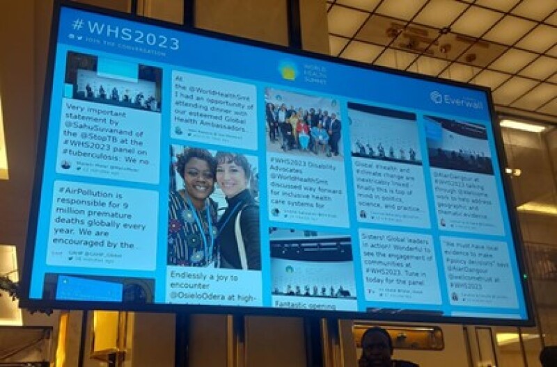 A photo of a large screen with social post.