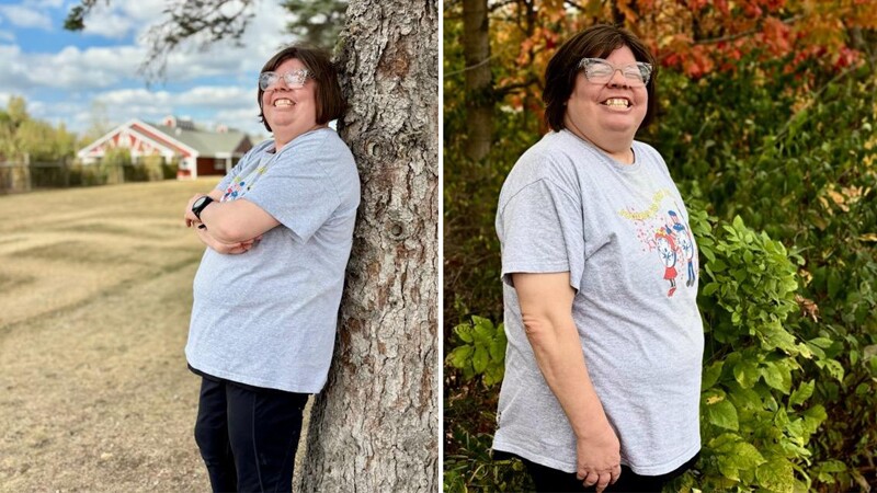 Young woman standing outside in front of trees. 