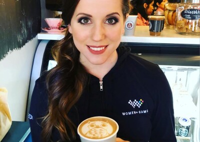 Jenn Panattoni holding a cup of coffee in a bakery.