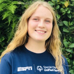 Elyssa Seelig standing outside wearing an EPSN and Special Olympics Unified Sports blue t-shirt. 