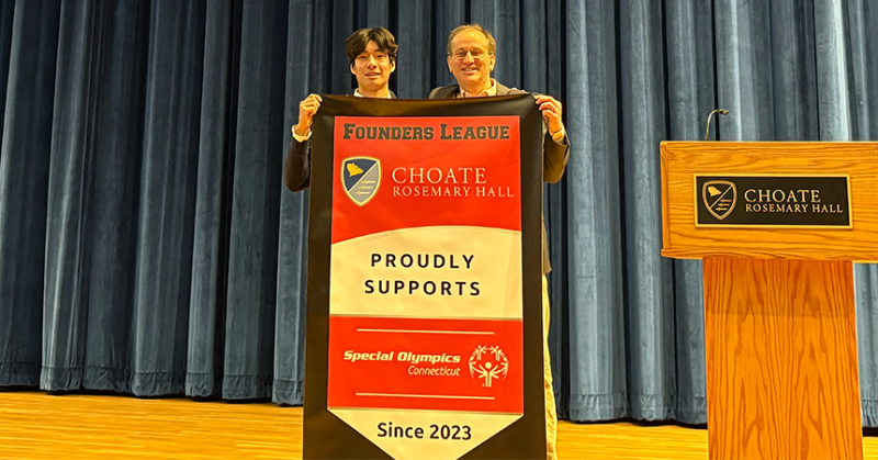 Two men stand holding a banner that reads "Founders League Choate Rosemary Hall Proudly Supports Special Olympics Connecticut since 2023"