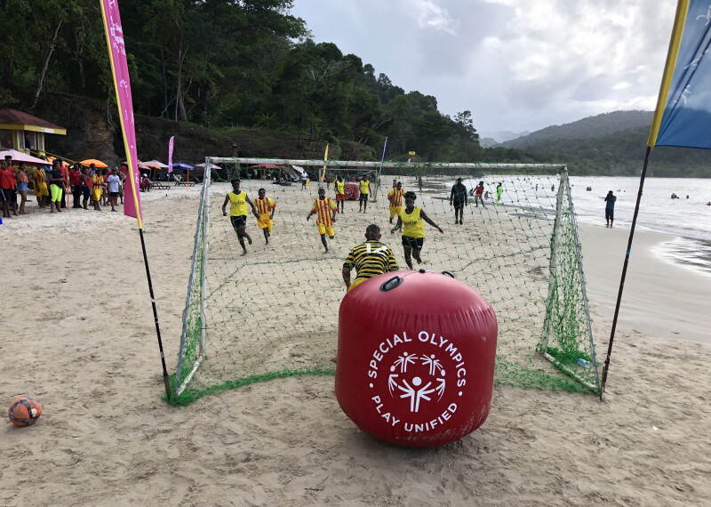 Athletes on the beach playing a game. 