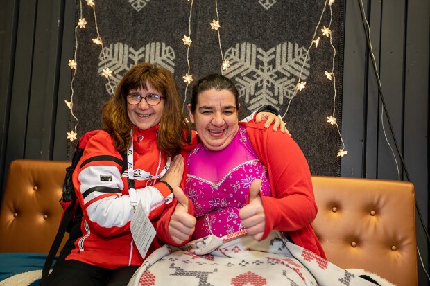 Coach and athlete sitting side by side giving a thumbs up.