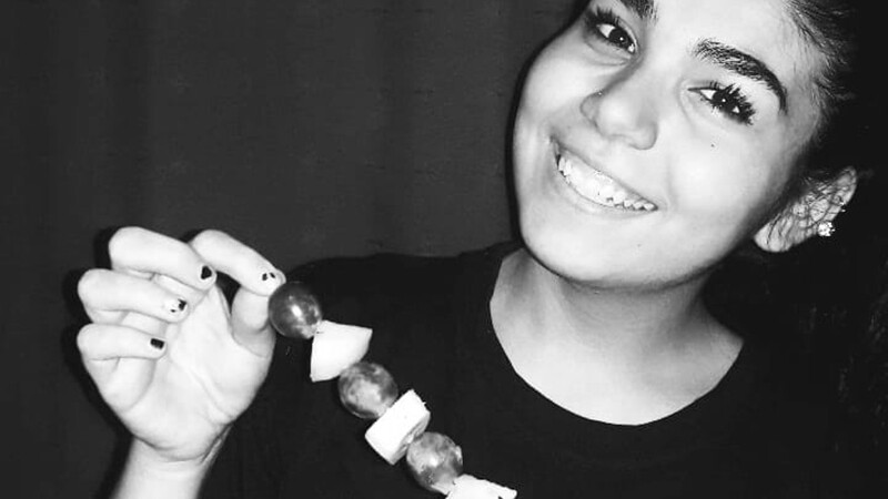 Special Olympics Argentina Youth Leader shows her fruit skewers.