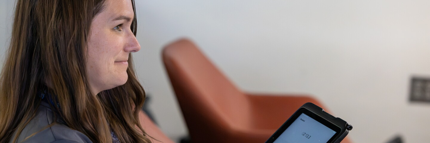 Woman sitting down using an interactive digital pad. 