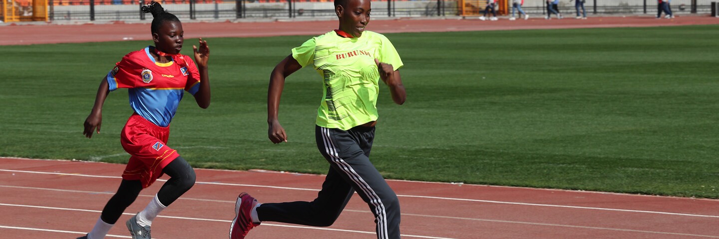 Two female athletes running on a track.