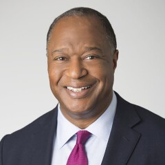 Dale Jones in a blue shirt, suite, and patterned tie.