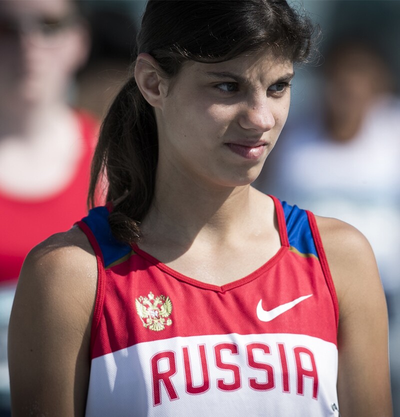 Tatiana Baranova, athlete leader from Special Olympics Russia standing on the field in an athletic tank-top that reads: Russia