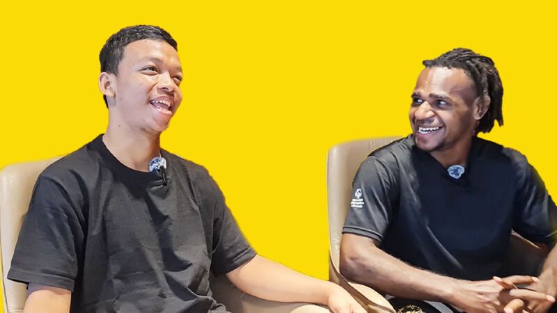 Two people sat in chairs next to each other laughing
