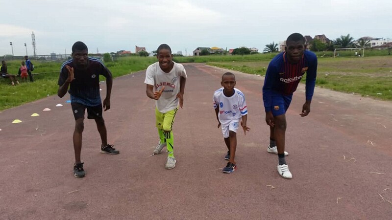 Four young men preparing to race down a track.