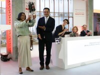 Woman holding a trophy with a smiling man standing beside her.