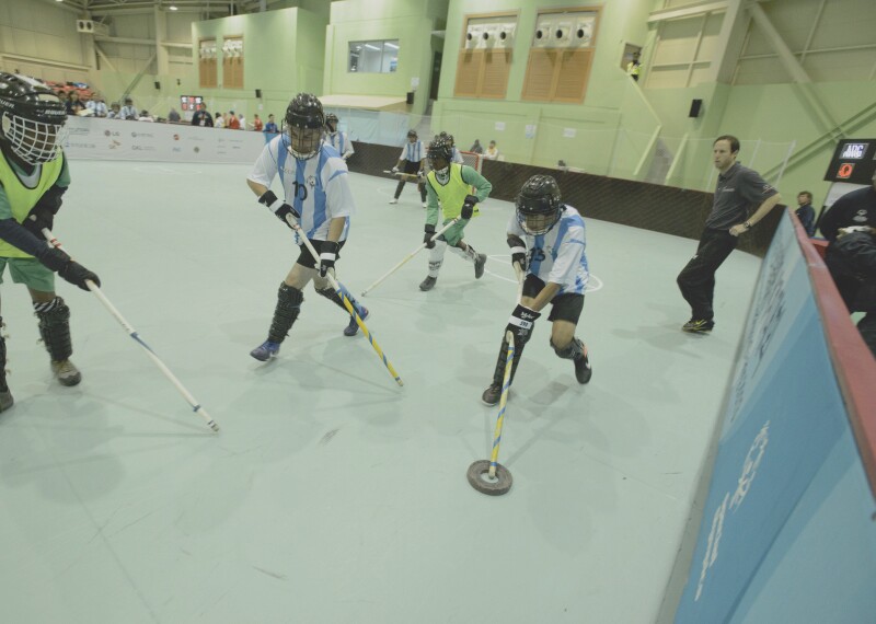 An athlete with the puck tries to make his way past a player for the opposing team.