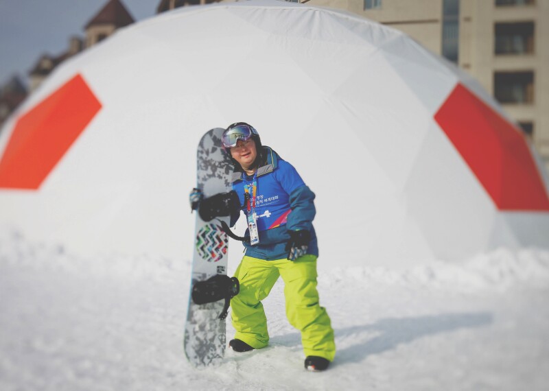 Athlete on the snow holding his board.