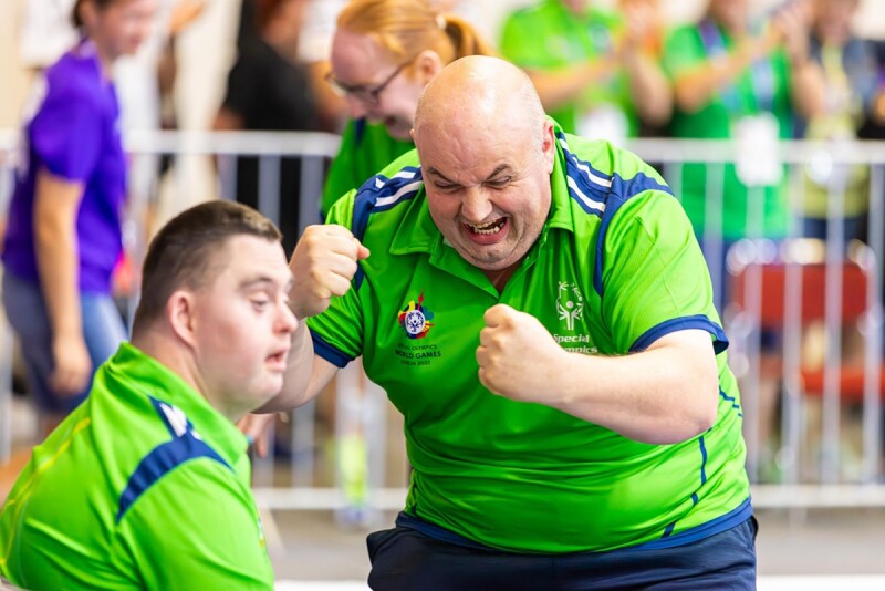 Athlete in green shirt celebrating with fists of joy 
