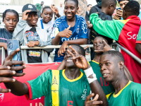 Two Special Olympics Senegal players posing with fans in the Stands