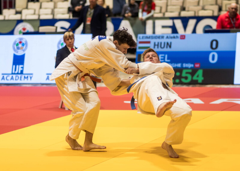 Two judokas in the middle of their match on the tatami.