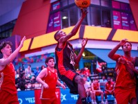 During a game, a player leaps for the ball as his opponents and teammates look up.