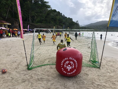 Athletes on the beach playing a game. 