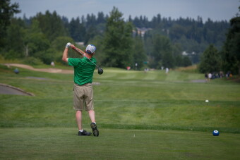 A male golfer just after striking the ball. 