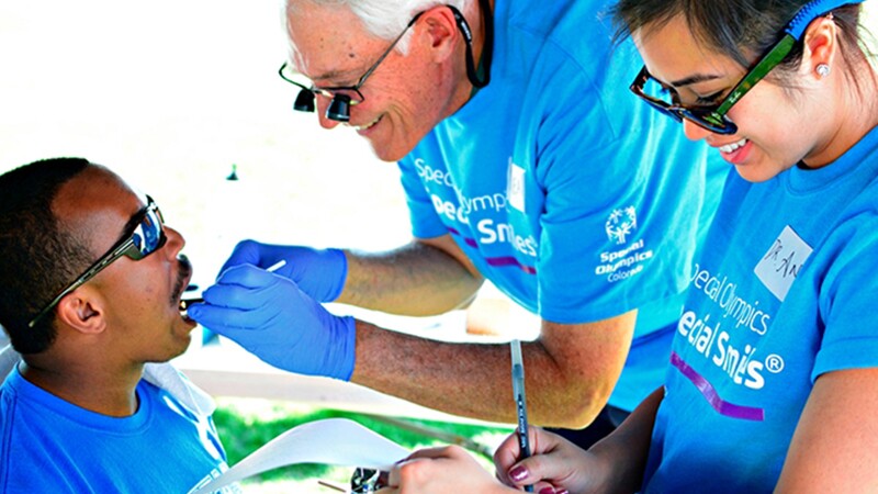 Athlete receiving a dental examination and an assistant takes notes.