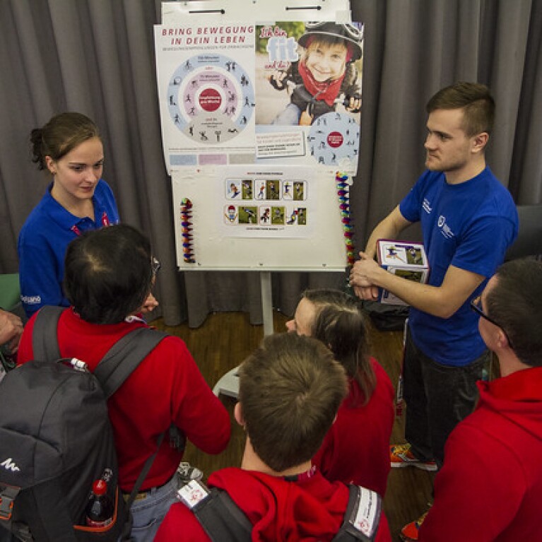 Athletes standing close to a presentation by Special Olympics Belgium representatives.