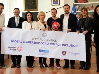 Group of people wearing formal clothing while holding a sign that says ‘Special Olympics Global Leadership Coalition for Inclusion’