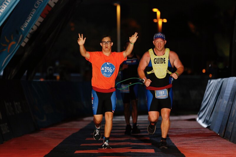 Chris Nikic and Dan Grieb cross the finish line at IRONMAN Florida in Panama City.